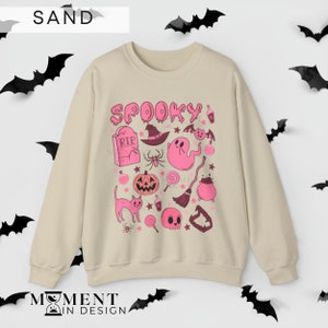 pink aesthetic halloween sweatshirt for women. contains pink graphics of ghosts, pumpkins, cats, potions, and candy.