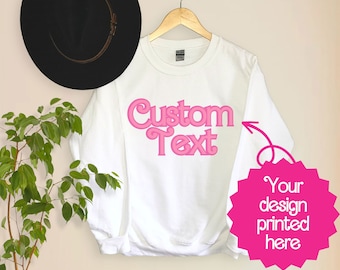 May include: White sweatshirt with pink text that says "Custom Text". The text is in a retro font style. A pink starburst with the text "Your design printed here" is in the lower right corner of the image.