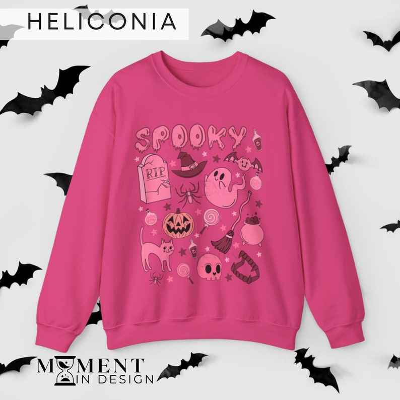 pink aesthetic halloween sweatshirt for women. contains pink graphics of ghosts, pumpkins, cats, potions, and candy.