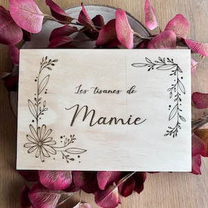 Puede incluir: Un letrero de madera con un diseño floral y el texto "Les tisanes de Mamie".
