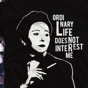 May include: Black t-shirt featuring a white silhouette of a woman with the text "Ordinary Life Does Not Interest Me"