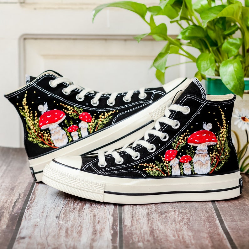 May include: Black high-top canvas sneakers with white soles and red and white mushroom embroidery.