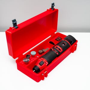 May include: A red plastic case with a black and red rotary tool and various attachments. The case is open and the tool is visible inside.