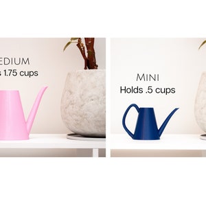 May include: Two watering cans, one pink and one blue, with the text "MEDIUM Holds 1.75 cups" and "MINI Holds .5 cups" above them.