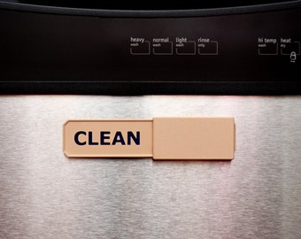May include: A rectangular beige sliding indicator sign with the word CLEAN printed in dark blue, attached to a stainless steel dishwasher door. The dishwasher control panel above features settings for heavy, normal, light, and rinse wash cycles.