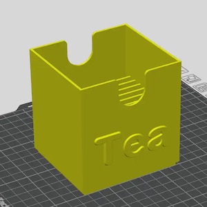 May include: A lime green, 3D-printed tea box with the word "Tea" embossed on the front. The box has a curved cutout on the top and a circular design on the side. The box is sitting on a black grid.