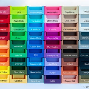 May include: A grid of colorful, small, plastic storage containers, each labeled with a different color name. Colors include Ruby Silk, Red, Red Matte, Maroon, Mandarin Matte, Pumpkin, Orange, Bright Yellow, Yellow Matte, Lime, Apple Matte, Grass Matte, Green, Mistletoe, Jade Silk, Emerald, Olive Matte, Gold Silk, Sky Blue Matte, Turquoise, Baby Blue, Marine Matte, Cobalt Blue, Blue, Sapphire Silk, Navy Matte, Blue Gray, Watermelon, Lt Pink Matte, Fuchsia, Magenta Silk, Plum Matte, Amethyst Silk, Lilac Matte, Purple, Indigo, Tan Matte, Latte Matte, Caramel Matte, Cocoa Matte, Cocoa, Dark Choc Matte, Brown, Terracotta Matte, Copper Silk, White, Lt Gray, Marble, Dark Gray, Ash Gray Matte, Charcoal Matte, Black, Onyx, Bronze.