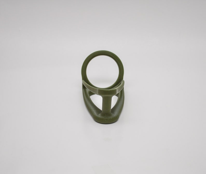 K&ouml;nnte beinhalten: Ein gr&uuml;ner Plastik-Ringhalter f&uuml;r eine Angelrute. Der Ring ist so konzipiert, dass er die Angelschnur an Ort und Stelle h&auml;lt.