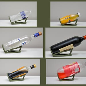 K&ouml;nnte beinhalten: F&uuml;nf verschiedene Flaschen mit verschiedenen Fl&uuml;ssigkeiten werden auf einem gr&uuml;nen Flaschenhalter aus Kunststoff gezeigt. Die Flaschen sind schr&auml;g positioniert, was die F&auml;higkeit des Halters zeigt, sie zu tragen.