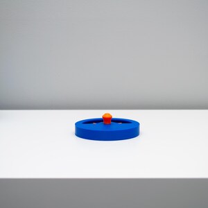 K&ouml;nnte beinhalten: Ein kreisf&ouml;rmiger blauer Kunststoffdeckel mit einem kleinen, mittig platzierten orangefarbenen Knaufgriff. Der Deckel hat eine flache, scheibenartige Form mit einem leicht erh&ouml;hten Rand und einer glatten Oberfl&auml;che f&uuml;r einen sicheren Verschluss.