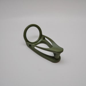 K&ouml;nnte beinhalten: Ein gr&uuml;ner Plastik-Ringhalter mit einer runden &Ouml;ffnung. Der Halter ist so konzipiert, dass er einen Ring sicher h&auml;lt.