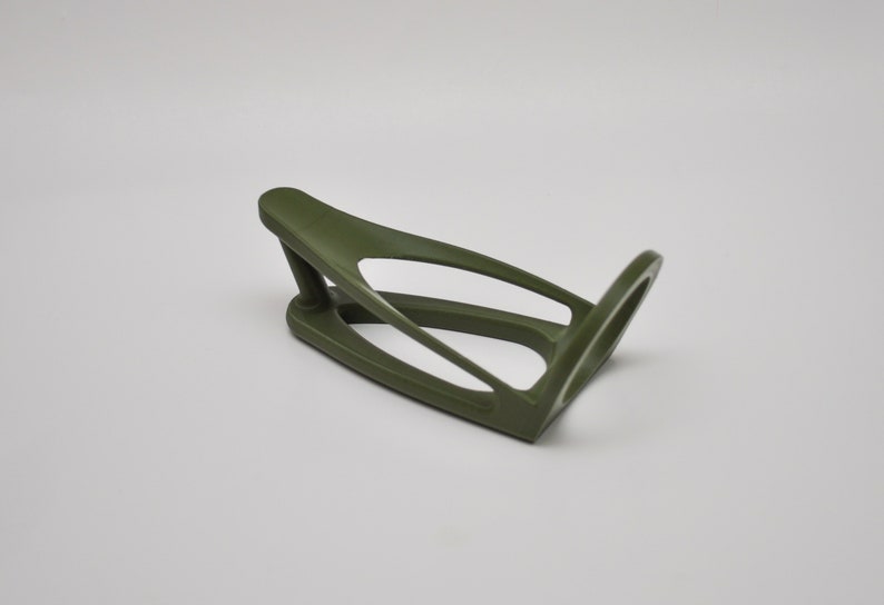 K&ouml;nnte beinhalten: Ein gr&uuml;ner Fahrrad-Wasserflaschenhalter aus Kunststoff. Der Halter ist so konzipiert, dass er an einen Fahrradrahmen passt.