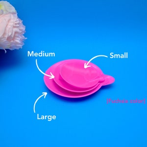 May include: Three fuchsia-colored, stackable, round lids labeled "Small", "Medium", and "Large". The lids are on a bright blue background. The text "[Fuchsia color]" is also present.