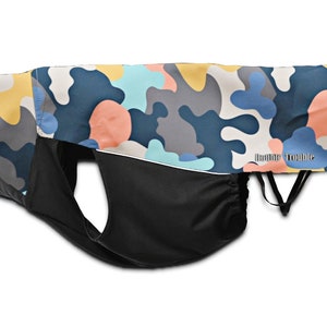 May include: A blue, yellow, pink, and gray camouflage dog coat with a black adjustable belly strap. The coat has the text "Rainy Trouble" printed on the back.