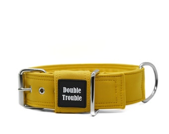 May include: A yellow dog collar with a silver buckle and a black tag that says "Double Trouble".