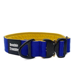 May include: A blue and yellow dog collar with a black buckle and a white label that says "Double Trouble".