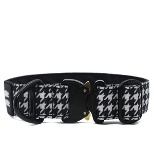 May include: Black and white houndstooth patterned dog collar with a black buckle and a gold accent.