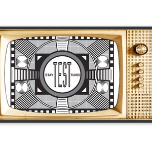 May include: A retro television set with a black frame and a gold-toned front. The screen shows a test card with the words "TEST" and "STAY TUNED". The TV features a dial and buttons on the right side, evoking a bygone era.