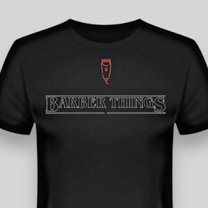Puede incluir: Camiseta negra con un contorno blanco de una máquina de afeitar y el texto "BARBER THINGS" en blanco.