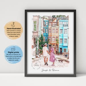 Könnte beinhalten: Ein gerahmter Druck im Aquarellstil mit einem Paar, das eine Kopfsteinpflasterstraße mit farbenfrohen Gebäuden entlanggeht. Der Druck enthält die Namen "Joseph & Riana" und Text, der darauf hinweist, dass er handillustriert und ein Digitaldruck ist.