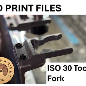 May include: A 3D printed tool fork for ISO 30 tools. The fork is gray and has a black screw on the side. The text "ISO 30 Tool Fork" is visible in the image.