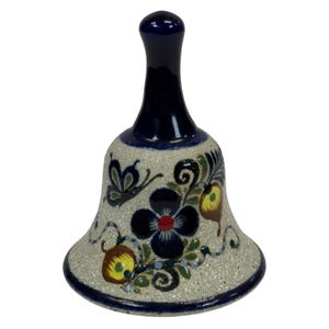 May include: A ceramic bell with a dark blue handle and rim. The bell has a speckled, light beige body with hand-painted floral and butterfly designs in dark blue, yellow, and red. The bell is a decorative item.