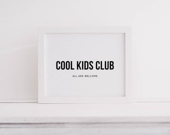 Peut inclure: Un cadre rectangulaire blanc contenant une impression blanche avec du texte noir. Le texte indique COOL KIDS CLUB dans une grande police sans empattement en gras, avec le texte plus petit ALL ARE WELCOME placé juste en dessous.