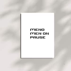 Könnte beinhalten: Ein weißer rechteckiger Druck mit dem Text "MENO MEN ON PAUSE" in fetter, schwarzer, serifenloser Schrift. Der Druck ist auf weißem Hintergrund zentriert, mit Schatten.
