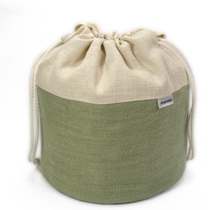 May include: A green and cream drawstring bag made of linen with a "MALIBU" label.