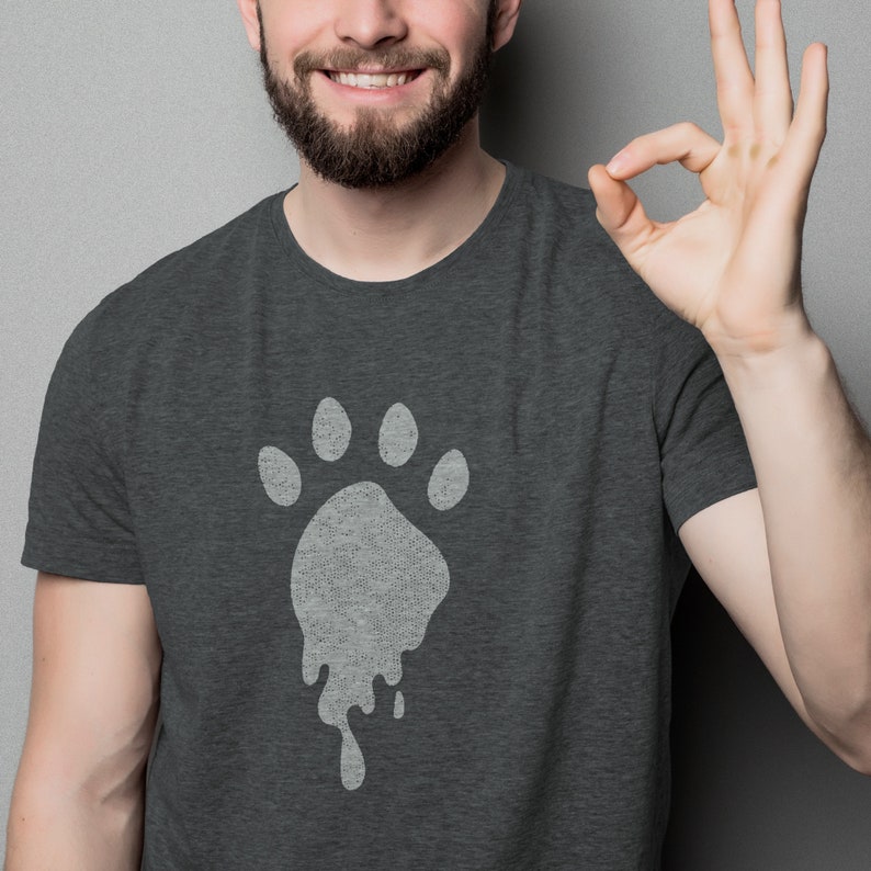 May include: A dark gray t-shirt with a white paw print design that appears to be dripping. The paw print is centered on the shirt.