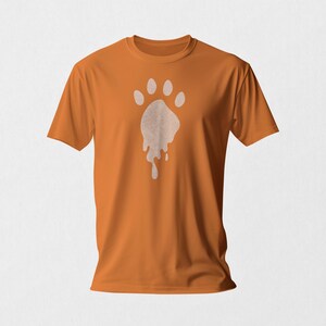 May include: Orange t-shirt with a white paw print design that appears to be melting. The paw print is centered on the shirt.