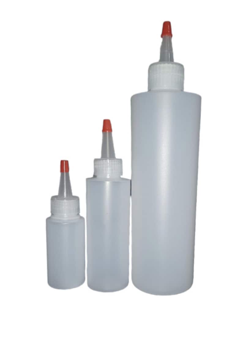 May include: Three clear plastic squeeze bottles with red caps and white lids. The bottles are different sizes.