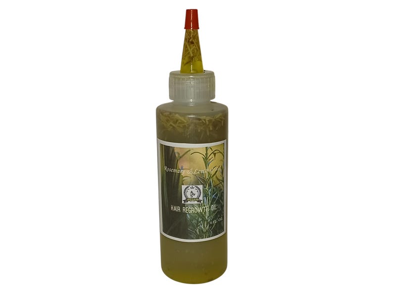 May include: A clear glass bottle with a red and yellow cap filled with a yellow liquid and green herbs. The bottle has a label that reads "Rosemary & Lemongrass Hair Regrowth Oil".