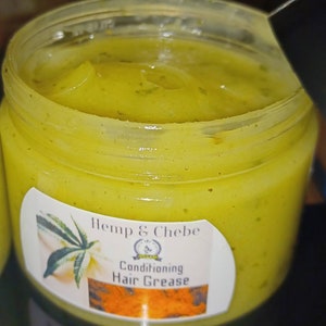 May include: A jar of Hemp & Chebe Conditioning Hair Grease. The product is a light green color and has a creamy texture. The label features a cannabis leaf illustration and the product name.