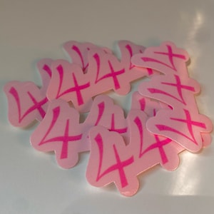 May include: A group of pink stickers with the number "4" written in a stylized font. The stickers are arranged in a random pattern.