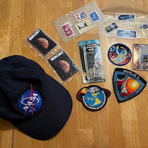 Souvenirs de l'exploration spatiale : écussons, cartes, chapeau, timbres-poste