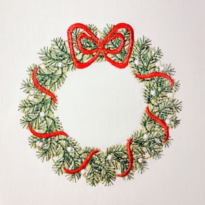May include: Embroidered Christmas wreath with green pine needles, white accents, and a red bow and ribbon. The wreath is circular and set against a white background, perfect for holiday decor.