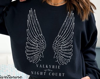 Może przedstawiać: Czarna bluza z białymi skrzydłami i nadrukiem "Valkyrie of the Night Court" z przodu.