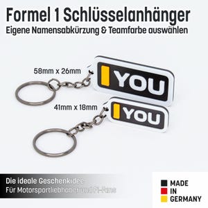 Könnte beinhalten: Zwei weiße und schwarze Schlüsselanhänger mit dem Wort "YOU" in schwarzen Buchstaben und einem gelben Streifen. Die Schlüsselanhänger sind in zwei Größen erhältlich: 58 mm x 26 mm und 41 mm x 18 mm. Die Schlüsselanhänger werden in Deutschland hergestellt.