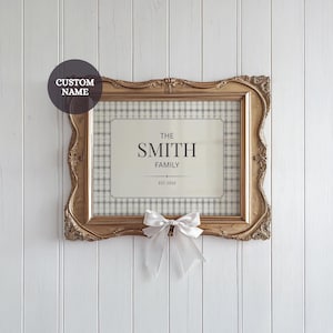 Puede incluir: Marco de fotos dorado ornamentado con un fondo a cuadros y un panel central que dice "THE SMITH FAMILY EST. 2015." Un lazo blanco está atado en la parte inferior. Una pegatina en la parte superior izquierda dice "CUSTOM NAME."