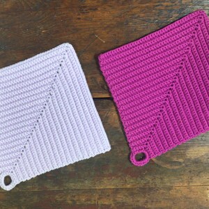 May include: Two crocheted pot holders, one lavender and one pink, with a loop handle on each.