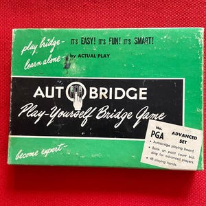 May include: A rectangular green box for the Autobridge play-yourself bridge game. The cover features white text reading Play bridge- learn alone, IT'S EASY! IT'S FUN! IT'S SMART!, and a label for the PGA Advanced Set with 48 playing hands.