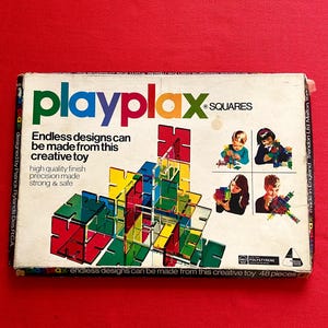 May include: A vintage Playplax Squares construction toy box on a red background. The box displays the Playplax logo in green, orange, and red, and text stating "Endless designs can be made from this creative toy." The box contains 48 pieces.