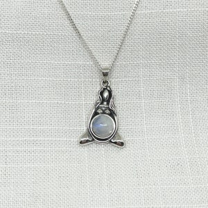 Peut inclure: Un collier en argent avec un pendentif en pierre de lune. Le pendentif est en forme de femme assise en position de lotus.