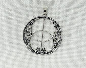 May include: A silver pendant necklace featuring a circular design with two overlapping circles and a vertical line in the centre. The circles are decorated with intricate floral patterns.