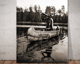 The Moose Call - Ojibway man in canoe, blowing a moose call. Photographed by Roland W. Reed in Minnesota.