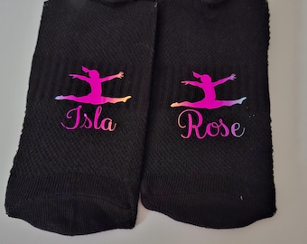 May include: Two black ankle socks with a pink and purple gymnast silhouette and personalised names "Isla" and "Rose" printed on them.