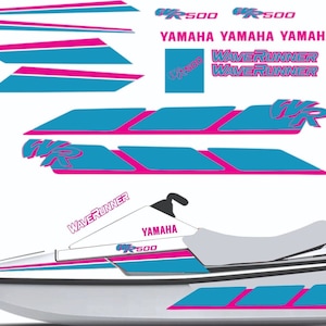 Puede incluir: Un jet ski Yamaha WaveRunner blanco con gráficos rosas y azules. Los gráficos incluyen las palabras "WaveRunner", "Yamaha" y "XR 500".