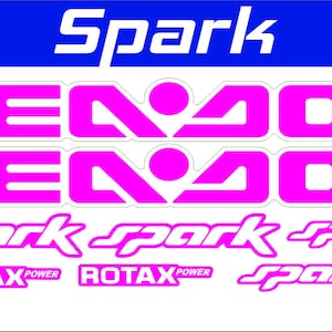 May include: A sheet of pink and white decals for a Spark personal watercraft. The decals include the word "Spark" in a stylized font, the word "SeaDoo" in a bold font, and the text "Rotax Power".