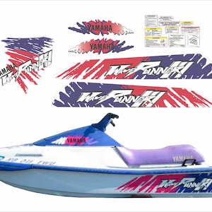 Könnte beinhalten: Weißer Yamaha Wave Runner Jetski mit roten, weißen und blauen Grafiken. Der Jetski hat eine blaue Windschutzscheibe und einen violetten Sitz. Die Grafiken beinhalten die Wörter "Wave Runner" und "Yamaha".